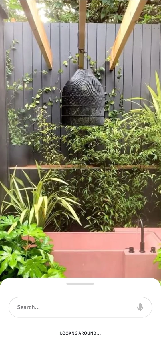Camera-based search view with a compact search sheet over an outdoor scene.